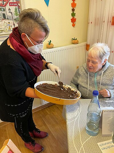 Seniorin backt mit Mitarbeiterin des Sozialen Diensts des Pflegeheims in Rosbach einen Waffelkuchen