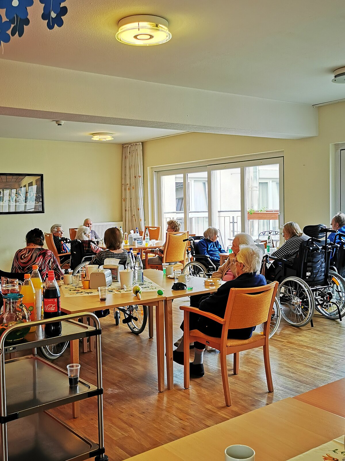 Bewohner sind zum Maifest in der Cafeteria des Seniorenzentrums Rosbach versammelt